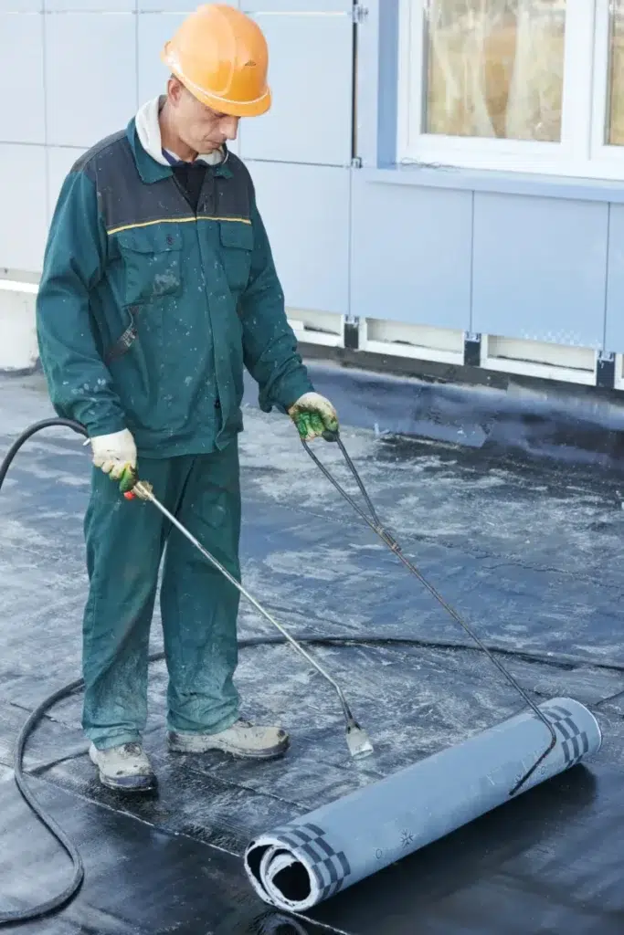 ASI Construction worker working on installing a flat roof on a commercial building.